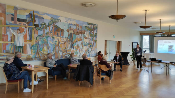 Stadens infotillfälle för nya Hangöbor i stadshusets foajé. Bildningsdirektören presenterar stadens skolor.