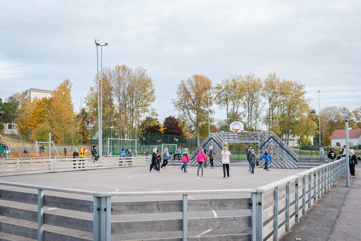 Oppilaat pelaavat koripalloa ulkokentällä.