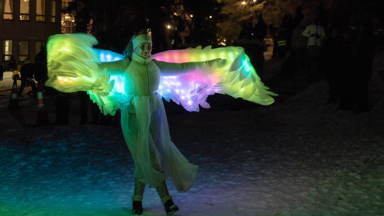 Hangö 150-jubileumsårets öppning i Kyrkparken. Damen har på sig ljusvingar med färg.