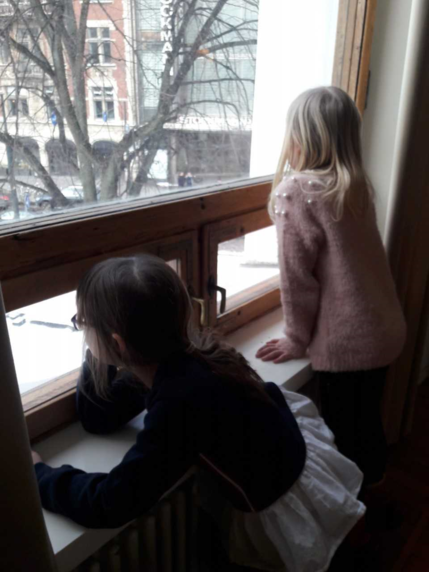 Kaksi tyttöä katsoo ikkunasta ulos.