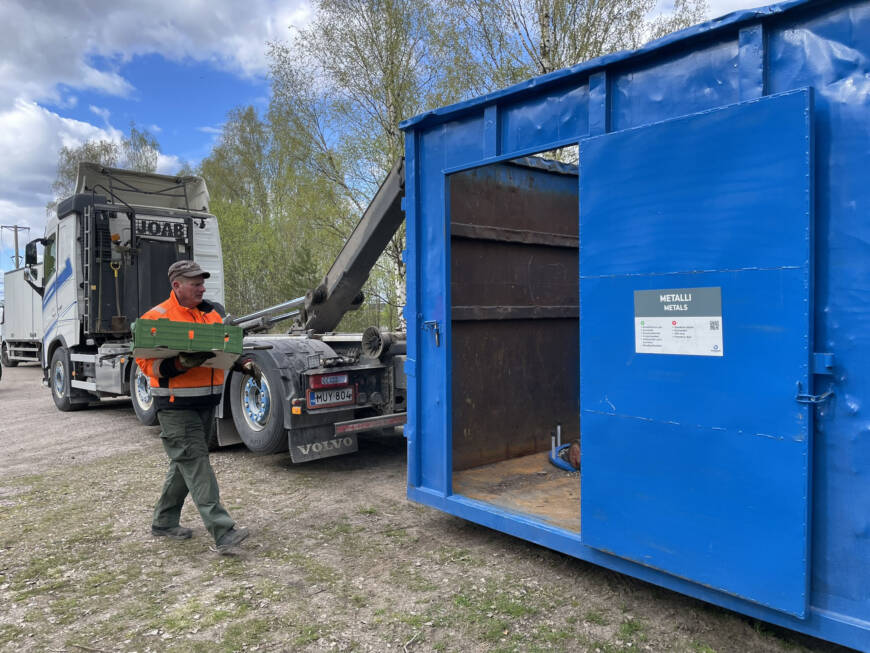 Metalliromun keräysauto, johon mies kantaa metalliromua.